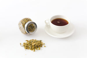 Herbs next to a cup of tea
